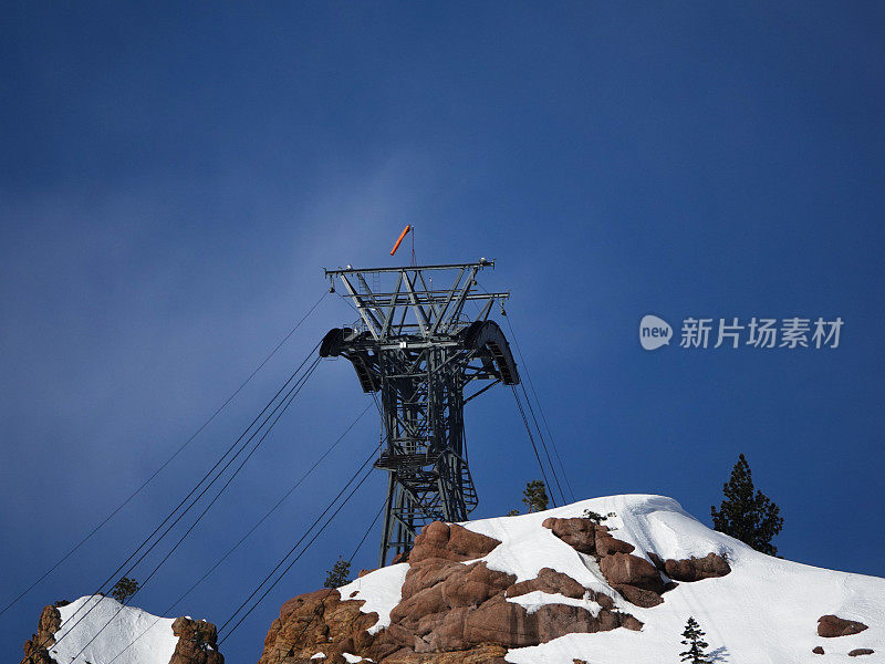 远摄摄岩石山峰上的有轨电车塔。Palisades Tahoe滑雪胜地，加利福尼亚。